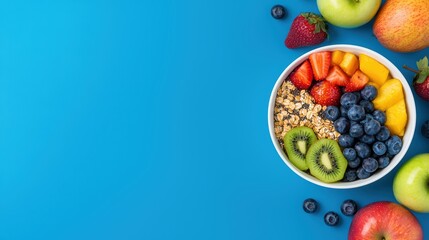 Colorful healthy fruit bowl with fresh berries, granola, and sliced fruits on bright blue background