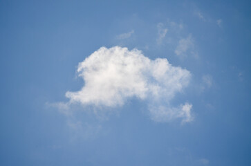A cloudless blue sky with a single cloud. The cloud is white and fluffy. The sky is clear and bright