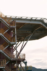 Obraz premium Industrial structure with metal stairs and ocean background