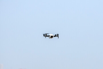 Drone is flaying against isolated blue sky