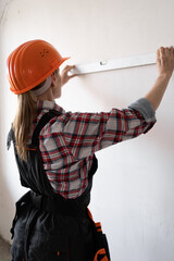 industrial worker renovating a house. builder worker measuring walls with spirit level