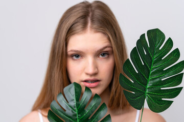 Teenager Russian girl isolated on white background holding a palm leaf. Close up portrait