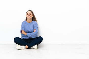 Young woman sitting on the floor keeping the arms crossed in frontal position