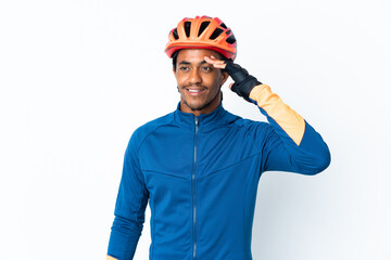 Young cyclist man with braids over isolated background saluting with hand with happy expression