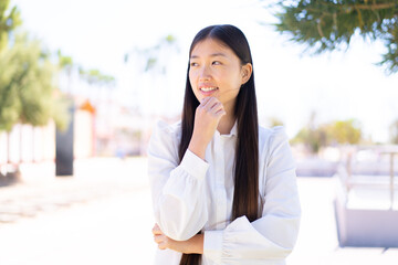 Fototapeta premium Pretty Chinese woman at outdoors looking to the side