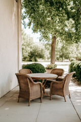 Fototapeta premium cozy outdoor seating area featuring elegant garden furniture with beautifully set table surrounded by lush greenery