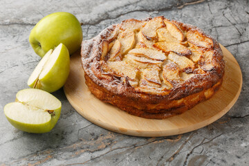Freshly baked clafoutis pie with apples with vanilla and cinnamon close-up on a wooden board on the...