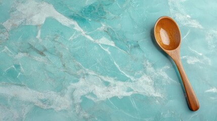 Wooden Spoon on Teal Marble Background