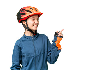 Teenager cyclist girl over isolated chroma key background pointing finger to the side and presenting a product