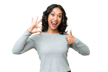 Young Argentinian woman over isolated background showing ok sign and thumb up gesture