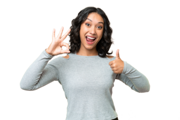 Young Argentinian woman over isolated background showing ok sign and thumb up gesture