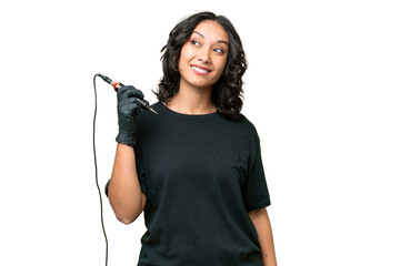 Tattoo artist Argentinian woman over isolated background thinking an idea while looking up