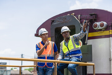 Railway Technicians Inspecting Train Locomotive, Engineers Collaborating on Train Maintenance, Railroad Workers with Walkie-Talkie on Duty