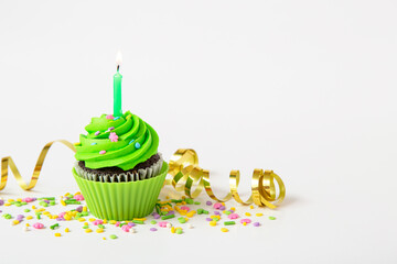 Colorful birthday cupcake with candle and festive decorations