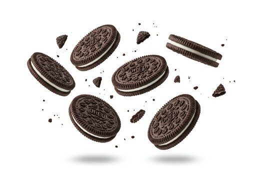 Oreo cookies floating in the air with crumbs scattered around on a clean white background studio shot