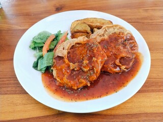 Double crispy tenderloin steak served with potato wedges, green vegetable and barbecue sauce