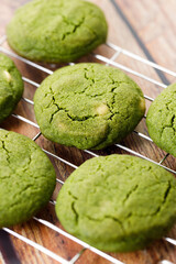 Chewy matcha chocolate chip cookies on cooling rack.
