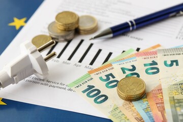 European union Euro money bills and coins with european electricity utility bill on table