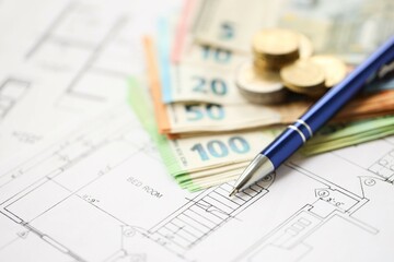 European union Euro money bills and coins with construction project blueprints on table