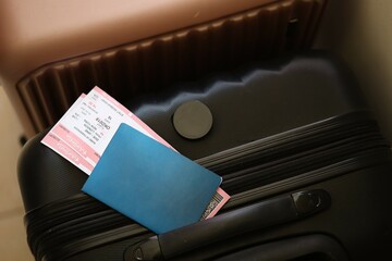Empty passport with tickets lies on touristic suitcase close up in airport waiting hall