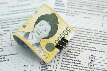 South Korean won money bills in big amount lies on table with tax forms close up