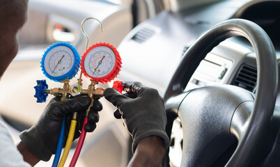 Mechanic Using AC Manifold Gauge in Car, Automotive Technician Checking Car Air Conditioning, Close-Up of Hands Operating Refrigerant Gauge