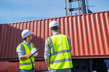 Logistics engineer and inspector working and discuss in shipping container in commercial transport port