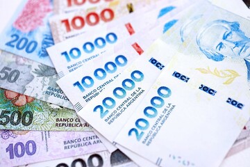 Argentine pesos money bills in big amount lies on white table close up