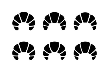 Six black croissant pastries on a white background