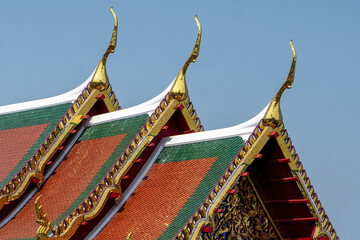 Roof design of a Thai building. Three layered wooden and clay tiles are used for sloping roofs in...