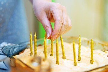 Lighting candles on a festive cake with wooden matches, capturing a warm celebratory moment