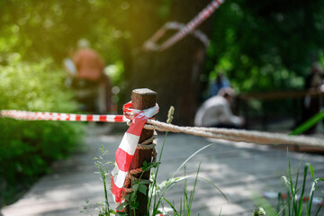 People ignoring safety rules by crossing the red-white barrier tape, demonstrating violation of established regulations