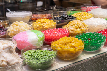 Colorful variety of toppings and ingredients commonly used in desserts, particularly in Southeast...