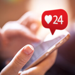 Female hand touching like button while using social media app on a smart phone. Social media interactions on mobile phone. Technology, internet and networking,  