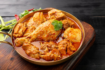 Chicken curry Asian food masala. Traditional cooking healthy food with spices. Arranged on black wooden table background.