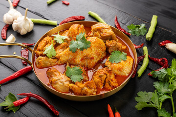 Chicken curry Asian food masala. Traditional cooking healthy food with spices. Arranged on black wooden table background.