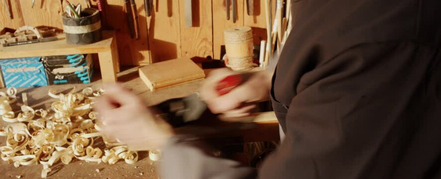 Falegname rifinisce pezzo di legno con pialletto o pialla - II