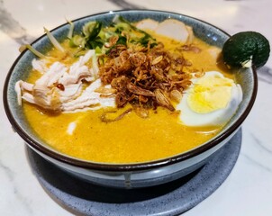 Indulge in the Aromatic Goodness of Laksa Lemak! A flavorful and spicy noodle soup made with coconut milk, featuring shrimp, tofu, eggs, and a hint of laksa leaf freshness.