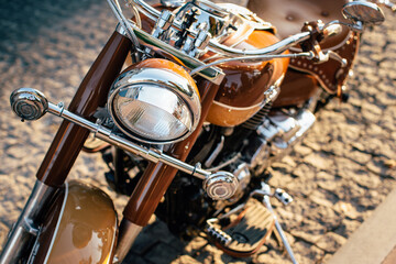 Shiny brown motorcycle parked on cobblestone street