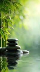 Fototapeta premium Tranquil Bamboo Setting With Stacked Stones Reflecting in Calm Water at Sunrise.