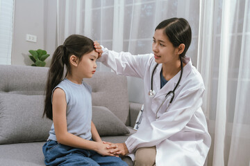 Obraz premium A smiling doctor examines a cute little girl at home, providing gentle care and health advice in a warm atmosphere.