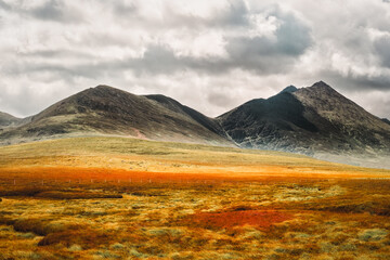 Scenic irish landscape view featuring mountain under a cloudy sky in County Kerry, Ireland.