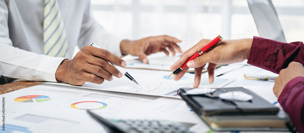 Poster a man and a woman are sitting at a table with a red pen and a calculator