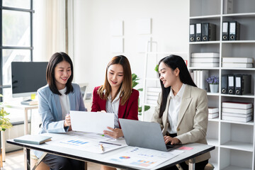 Fototapeta premium Three women are sitting at a table with papers in front of them