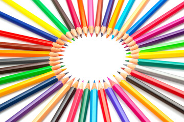 Multicolored pencils arranged in a circular pattern against a white backdrop, forming a central...