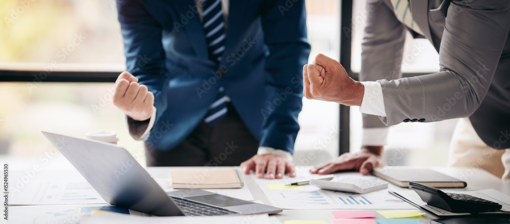 Aufkleber Two men are standing at a table with a laptop and a stack of papers