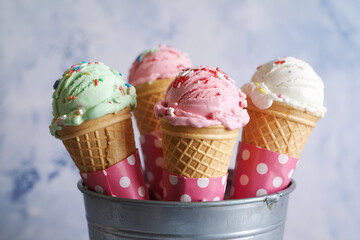 Ice cream cones with sprinkles in rustic metal bucket