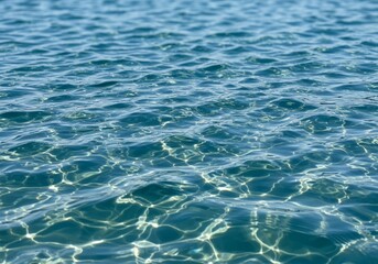 Obraz premium Sunlit blue water with ripples and light play.