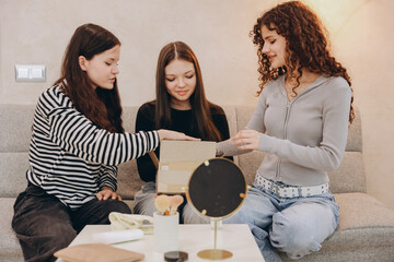 Teenage girls opening a delivery box with beauty products