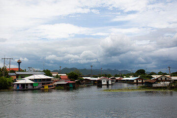 View landscape Si Sawat river and life of thai people with antique home and resort guest house on rafting floating in Khwae Yai river for travelers travel visit and rest relax at Kanchanaburi Thailand